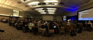 A panoramic shot of the 2018 SIGCSE plenary showing hundreds of attendees in chairs.